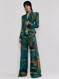 Teal and mustard yellow graphic print suit, featuring a structured blazer and wide-leg trousers.